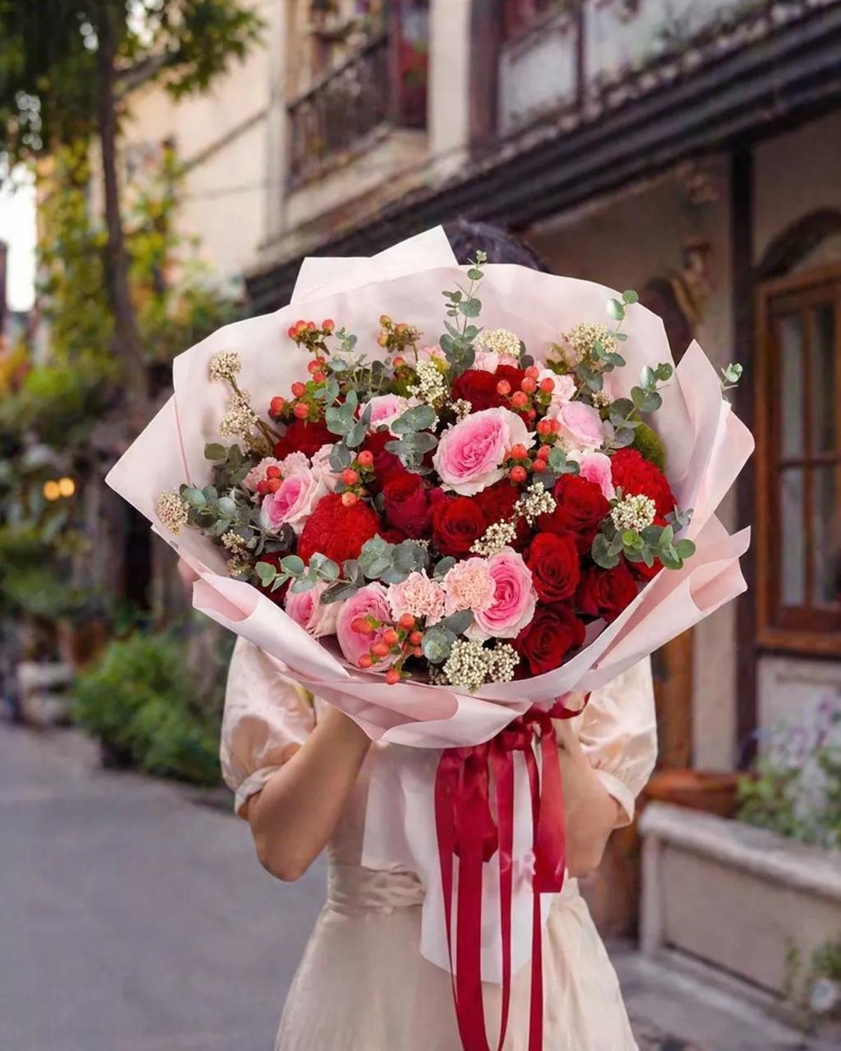 Express your deepest feelings with this elegant arrangement of premium crimson and blush pink roses. Accented with unique red celosia and ruffled carnations, this textured bouquet offers a sophisticated look for anniversaries or romantic surprises. Fresh eucalyptus and delicate white fillers add a natural touch, all beautifully presented in a soft pink wrap with a burgundy ribbon. It is a perfect choice for premium gifting in Chiang Mai.